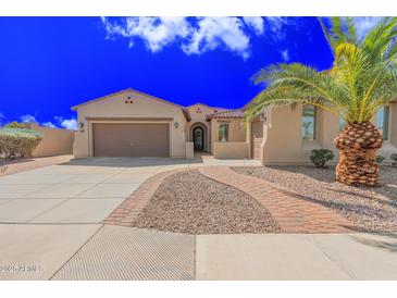 Charming single-story home with a well-manicured yard, complemented by a beautiful palm tree at 6616 S Bridal Vail Dr, Gilbert, AZ 85298