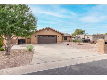 Single story home with a two-car garage and landscaped yard at 9543 E Palomino Pl, Sun Lakes, AZ 85248