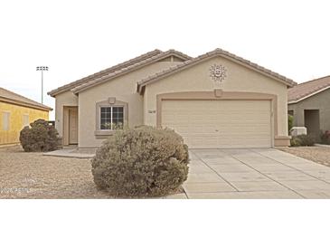 One-story house with tan exterior, two-car garage, and desert landscaping at 15239 N 153Rd Dr, Surprise, AZ 85379