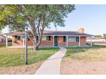 Brick ranch house with covered porch, mature tree, and walkway at 6850 N 15Th Pl, Phoenix, AZ 85014