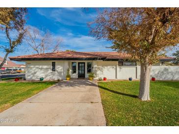 Updated mid-century modern home with landscaped lawn and driveway at 1001 N Burk St, Gilbert, AZ 85234