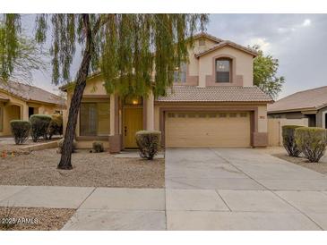 Two-story house with beige exterior, two-car garage, and landscaping at 17427 W Rock Wren Ct, Goodyear, AZ 85338