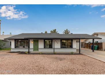 Charming single story home with a green door and gravel driveway at 615 W Enid Ave, Mesa, AZ 85210