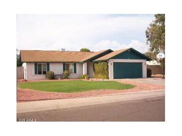 Single-story home with green door and well-maintained lawn at 6820 W Cameron Dr, Peoria, AZ 85345