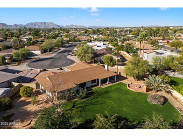 Aerial view of single-story home, spacious backyard, and mountain views at 7550 E Ironwood Ct, Scottsdale, AZ 85258