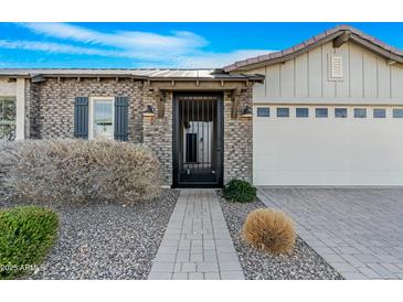 Craftsman style home with brick and siding exterior, gated entry, and two-car garage at 10053 E Seismic Ave, Mesa, AZ 85212