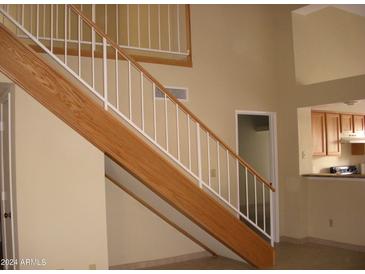 Indoor view of a wooden staircase with a white railing at 2138 W Beaubien Dr, Phoenix, AZ 85027