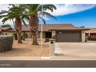 Single-story home with a two-car garage and mature landscaping at 26602 S Nicklaus Dr, Sun Lakes, AZ 85248