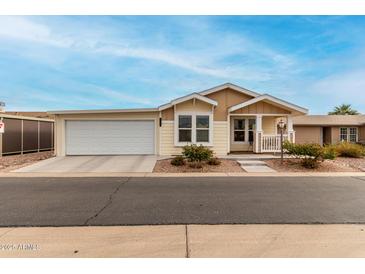 Tan house with white trim, attached garage, and small porch at 3301 S Goldfield Rd # 4065, Apache Junction, AZ 85119