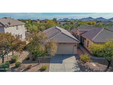 Aerial view of a single-story house with a private backyard, two-car garage, and mountain views at 40901 N Courage Trl, Anthem, AZ 85086