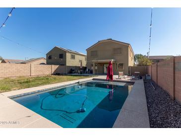 Inviting backyard oasis with a sparkling pool and patio area at 5496 S 237Th Ln, Buckeye, AZ 85326