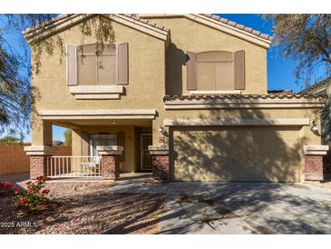 Two-story house with a tan exterior, attached garage, and landscaping at 5496 S 237Th Ln, Buckeye, AZ 85326