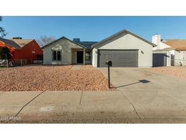 Newly renovated single-story home with a modern gray garage door at 7602 W Minnezona Ave, Phoenix, AZ 85033