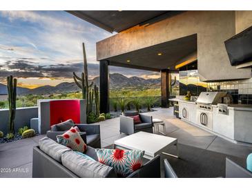 Inviting covered outdoor space with comfortable seating, built-in grill and stunning mountain views at 11541 E Salero Dr, Scottsdale, AZ 85262