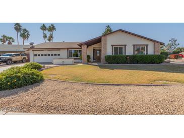 Single-story home with a well-maintained lawn and a two-car garage at 13872 N 89Th St, Scottsdale, AZ 85260