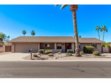 Single-story home with landscaped yard and two-car garage at 1518 N 62Nd Pl, Mesa, AZ 85205