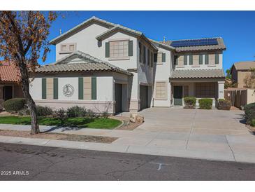 Two-story house with solar panels, landscaped lawn, and a two-car garage at 16370 W Adams St, Goodyear, AZ 85338