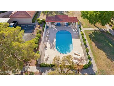 Inviting community pool with surrounding patio furniture and landscaping at 17243 N 16Th St # 1, Phoenix, AZ 85022