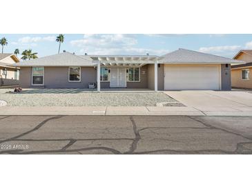 Gray brick ranch house with white pergola and attached garage at 17635 N Buntline Dr, Sun City West, AZ 85375