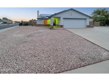 House exterior featuring a two-car garage and landscaping at 19002 N 47Th Dr, Glendale, AZ 85308