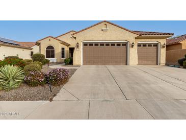 Tan two-story house with a three-car garage and landscaped front yard at 20359 N 262Nd Dr, Buckeye, AZ 85396