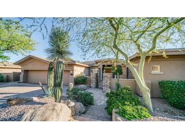 Desert landscaping accents this single-story home's stucco exterior, highlighting a charming entrance at 211 E Desert Wind Dr, Phoenix, AZ 85048