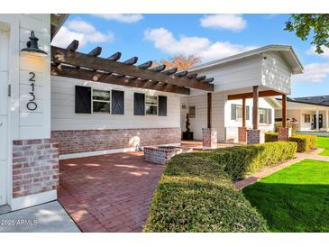 Inviting front porch with brick flooring and pergola at 2130 E San Juan Ave, Phoenix, AZ 85016