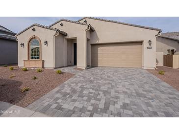 Single-story home with light beige exterior, two-car garage, and landscaped front yard at 21418 W Meadowbrook Ave, Buckeye, AZ 85396