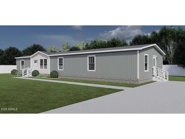 Gray manufactured home with white accents, landscaping, and driveway at 2693 S 357Th Dr, Tonopah, AZ 85354