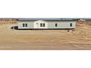 New manufactured home with a gray exterior and white trim on a desert lot at 2693 S 357Th Dr, Tonopah, AZ 85354