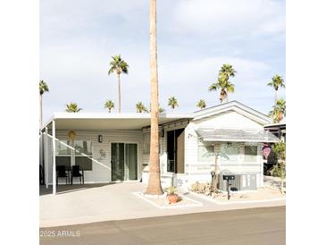 Single-wide manufactured home with covered patio and desert landscaping at 303 N Lindsay Rd # N12, Mesa, AZ 85213