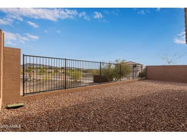 Backyard with gravel and a metal fence, offering a low-maintenance landscape at 31817 N 124Th Dr, Peoria, AZ 85383