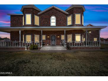 Brick house with a wrap-around porch, and a landscaped yard at 424 E Lehi Rd, Mesa, AZ 85203