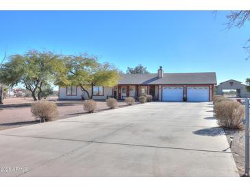 Ranch-style home with a large driveway and mature landscaping at 52615 W Esch Trl, Maricopa, AZ 85139