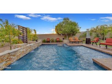 Inviting backyard pool with a stone waterfall feature and comfortable lounge seating at 5424 N 186Th Dr, Litchfield Park, AZ 85340