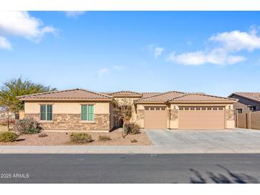 Single-story home with stone accents and a three-car garage at 5758 W Kowalsky Ln, Laveen, AZ 85339