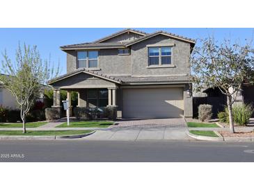 Charming two-story home featuring a well-manicured lawn and welcoming front porch at 9750 E Radioactive Dr, Mesa, AZ 85212