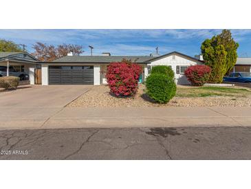 Charming single story home with landscaped front yard and modern garage door at 6808 E Loma Land Dr, Scottsdale, AZ 85257