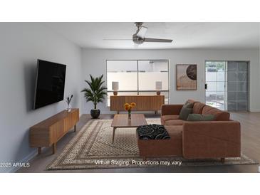 Bright living room with stylish furniture, neutral walls, ceiling fan, and sliding glass doors to the outside at 1051 S Dobson Rd # 165, Mesa, AZ 85202