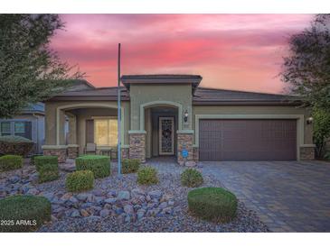 Single-story home with attractive landscaping and a two-car garage at 11047 E Tupelo Ave, Mesa, AZ 85212