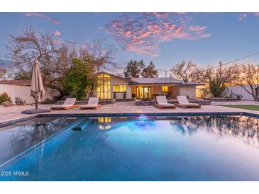 Inviting pool with lounge chairs, surrounded by a beautifully landscaped backyard at 1422 W Colter St, Phoenix, AZ 85013