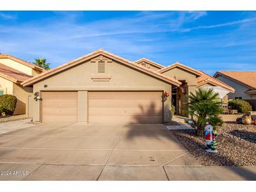 Tan house with three-car garage, desert landscaping, and festive decorations at 16813 S 37Th Way, Phoenix, AZ 85048