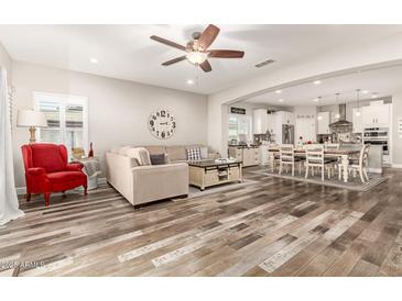 Open concept living room with a view into the kitchen and dining area at 17502 W Blue Sky Dr, Surprise, AZ 85387