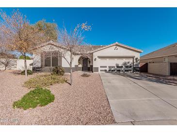 Single-story home with a two-car garage and well-maintained landscaping at 18354 W Hatcher Rd, Waddell, AZ 85355