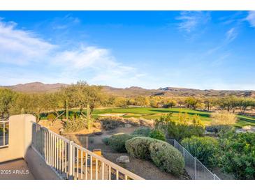 Scenic view of a golf course and mountains from a backyard patio at 19115 E Tonto Verde Dr, Rio Verde, AZ 85263