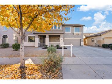 Two-story house with a gray facade,fall leaves and a neatly landscaped front yard at 19359 E Canary Way, Queen Creek, AZ 85142