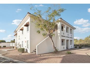 Two-story building with Spanish-style architecture and a landscaped courtyard at 2950 W Louise Dr # 203, Phoenix, AZ 85027