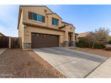 Two-story house with a brown door and large driveway at 39979 W Robbins Dr, Maricopa, AZ 85138