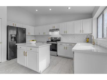 Modern kitchen with white cabinets, stainless steel appliances, and a large island at 5429 W Kerry Ln, Glendale, AZ 85308