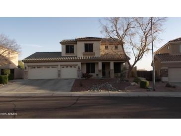 Two-story house with three-car garage and landscaped front yard at 7409 W Briles Rd, Peoria, AZ 85383